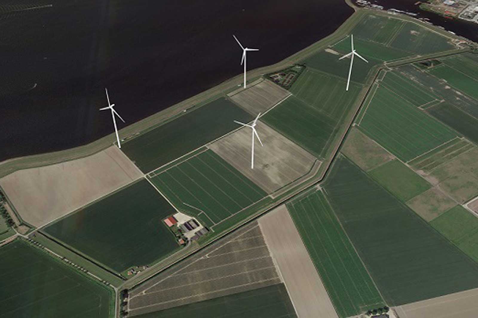 Luchtopname van groene velden met windturbines nabij een donker wateroppervlak.
