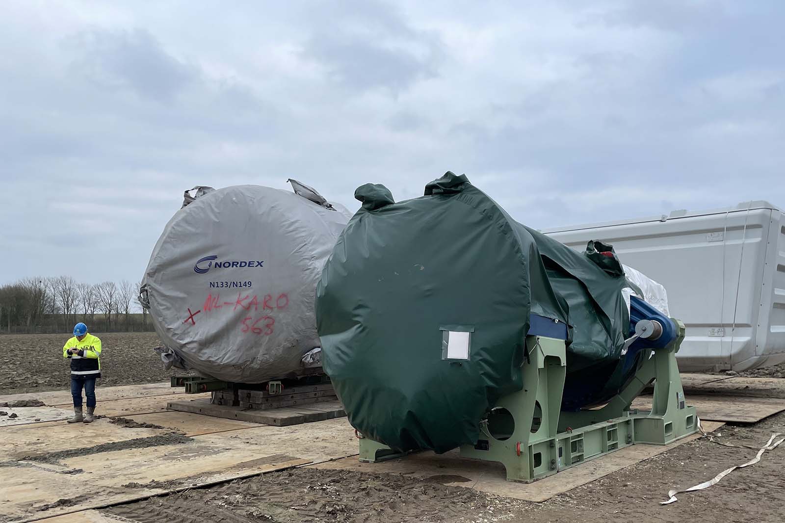 Twee afgedekte turbine gondels met opdruk NORDEX M-KARO 563 en medewerker