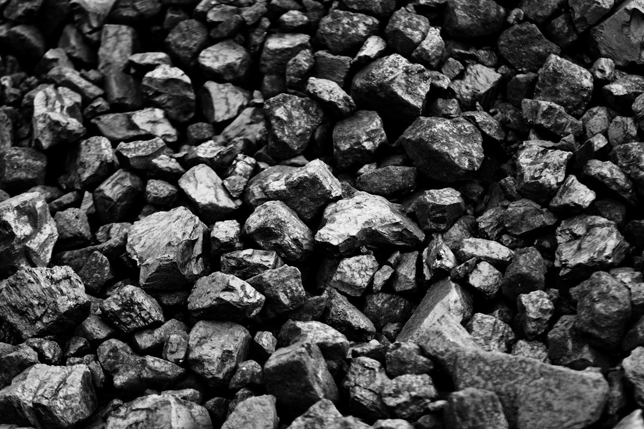 Een close-up van een berg donkere, ongelijkmatig gevormde stenen, die de ruwe texturen en hoekige randen benadrukt.