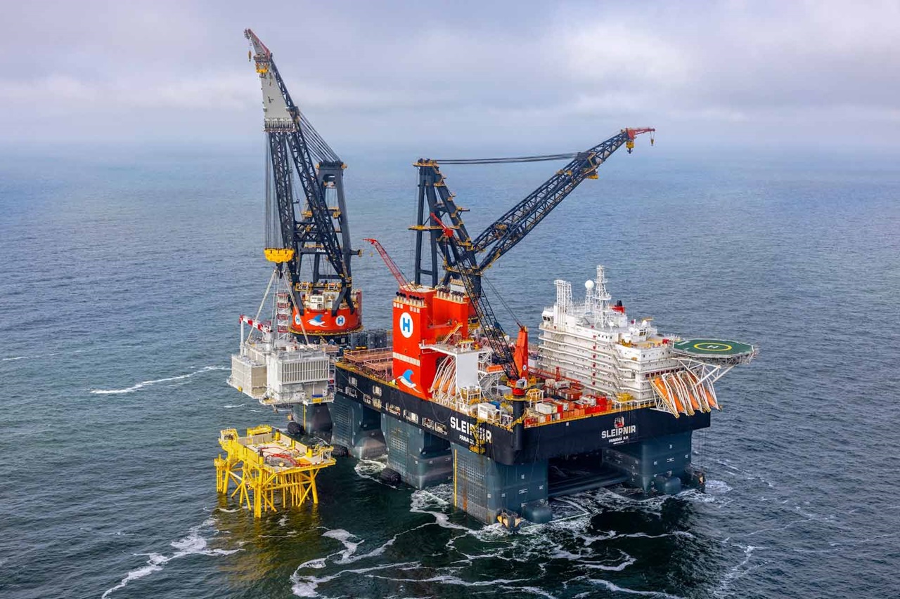An offshore crane vessel named Sleipnir, featuring two large cranes and a yellow installation platform in the ocean.