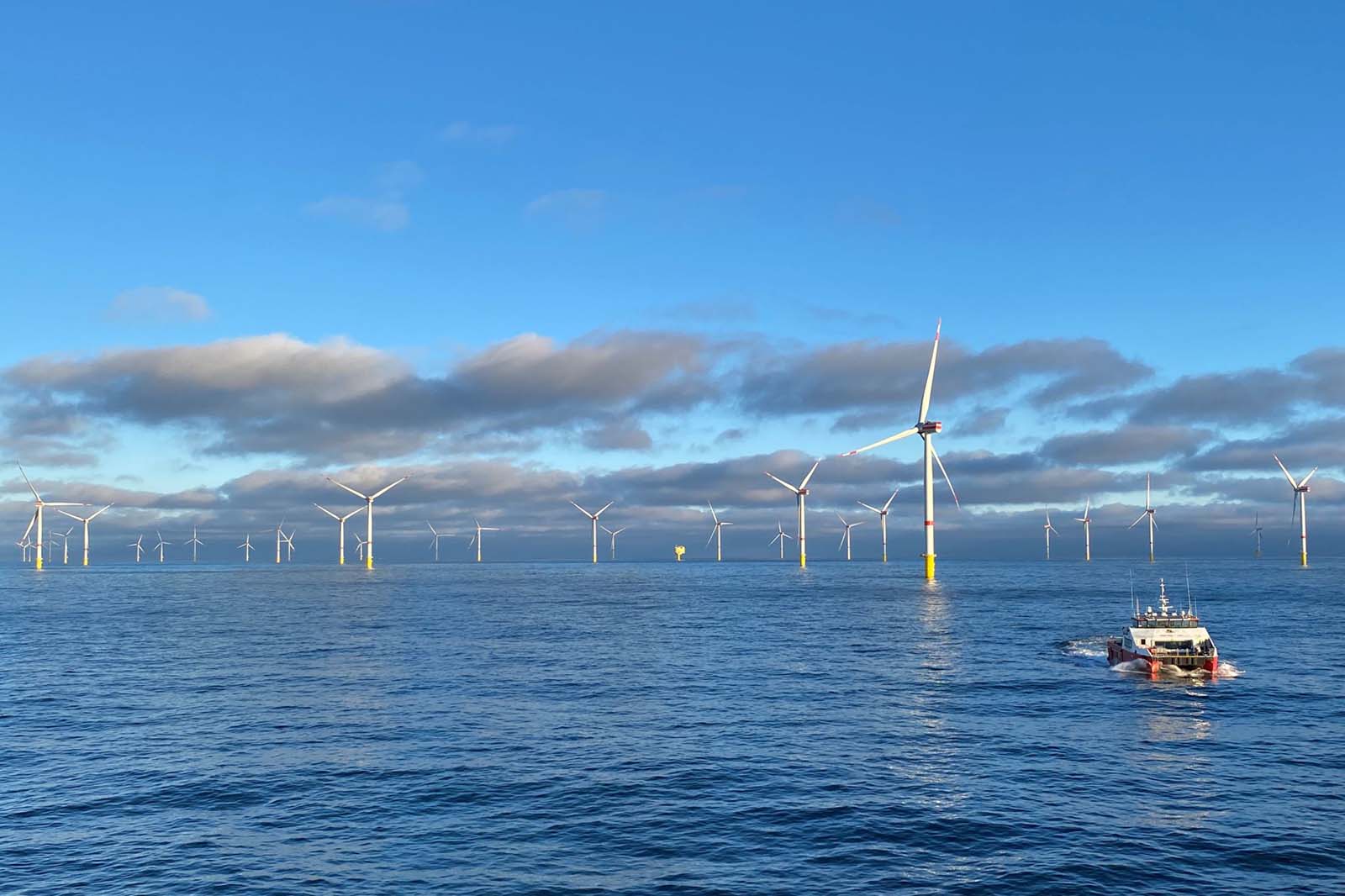 Offshore windmolens op kalme zee met serviceboot